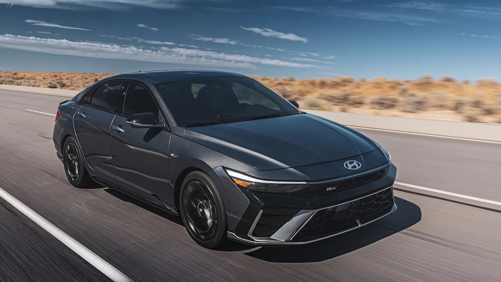 A gray 2027 Hyundai Elantra sedan driving down a desert road